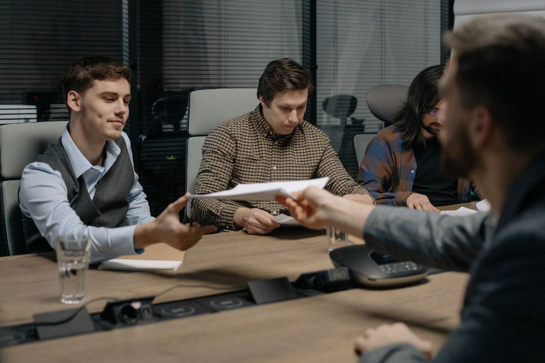 Business people reviewing documents across a conference table during UK small business acquisitions negotiation