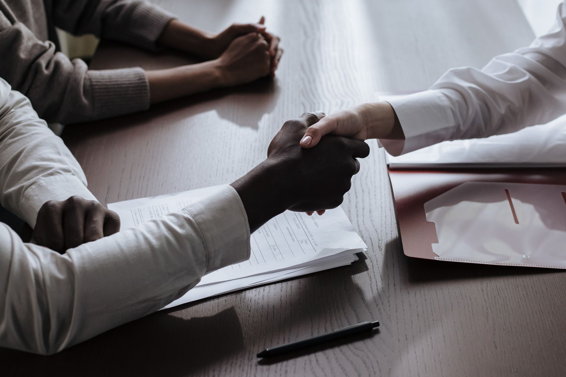 Business handshake over loan documents symbolising small business lending agreement