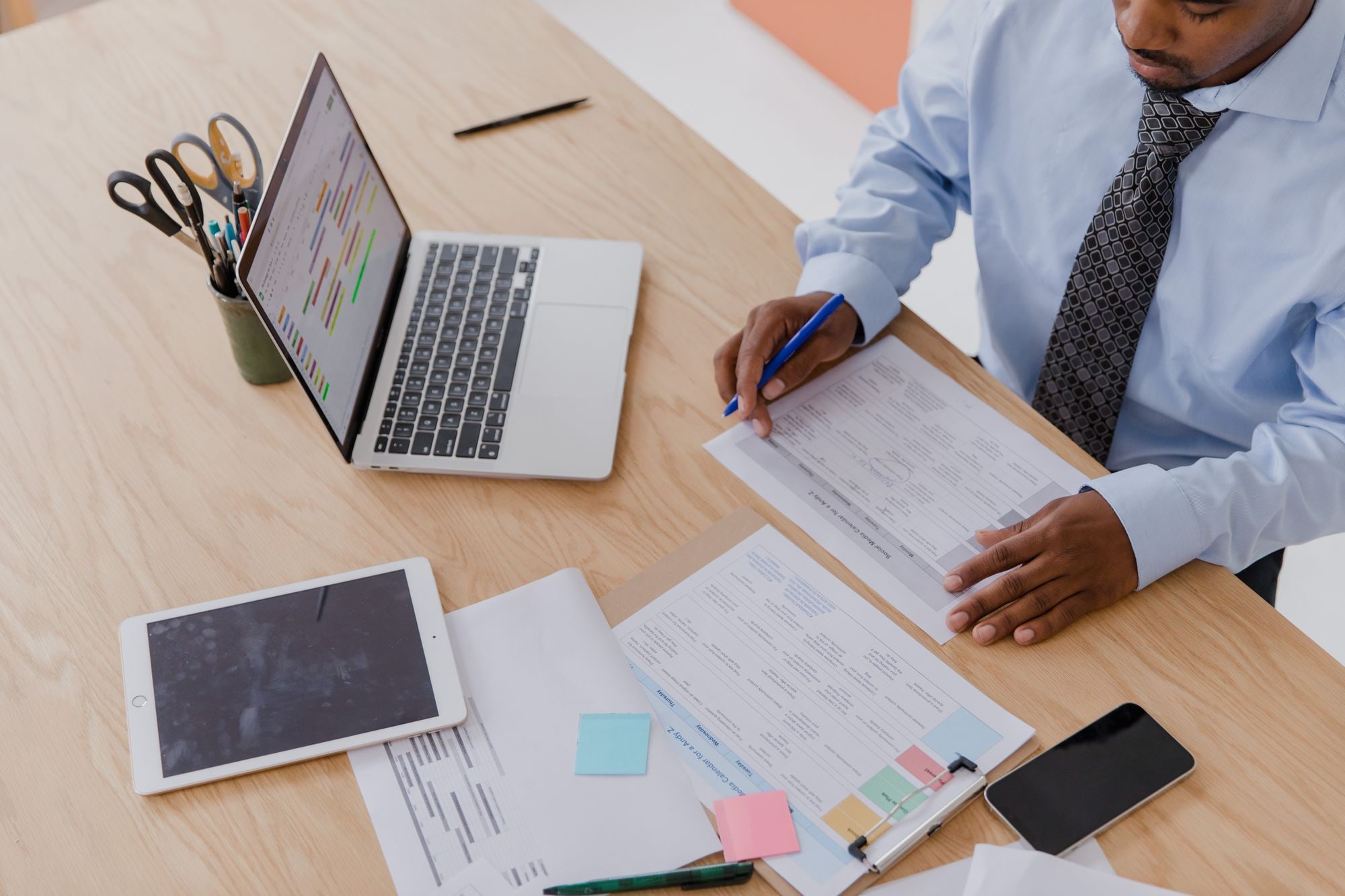 Businessman reviewing paperwork and laptop at desk, illustrating how to choose the right SIC codes for a UK company