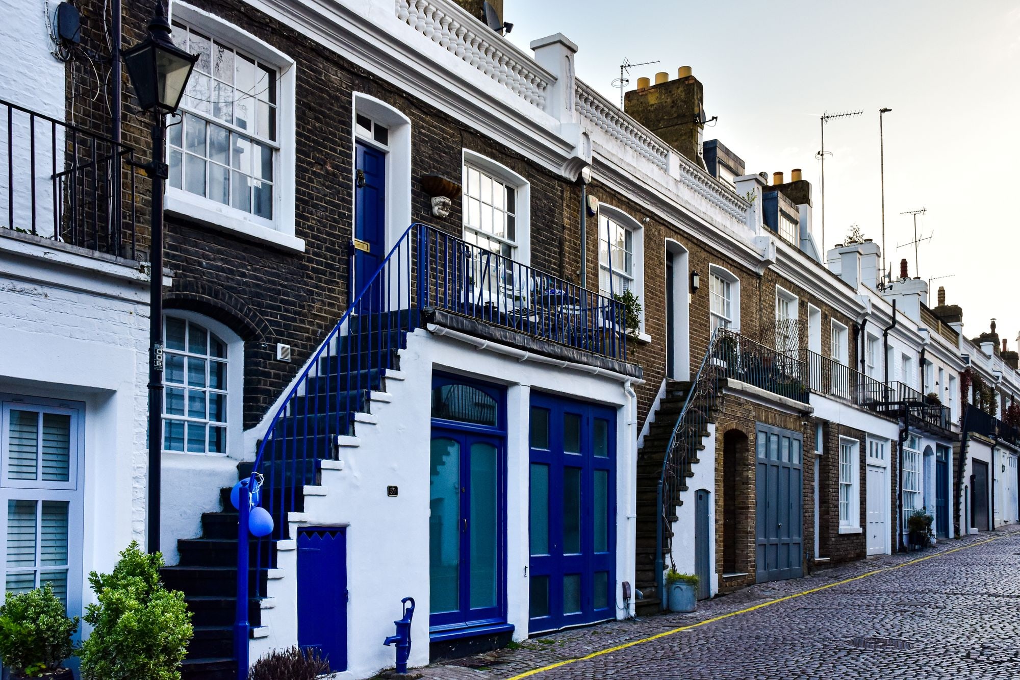 Row of British mews houses on a cobbled street, illustrating a short let business UK property market