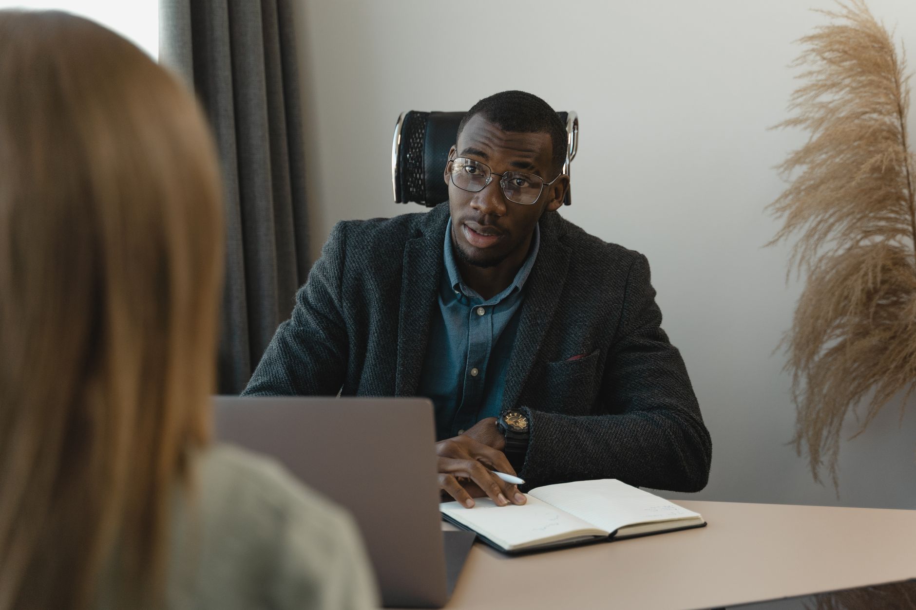 Businessman interviewing a candidate at a desk, illustrating small business hiring growth