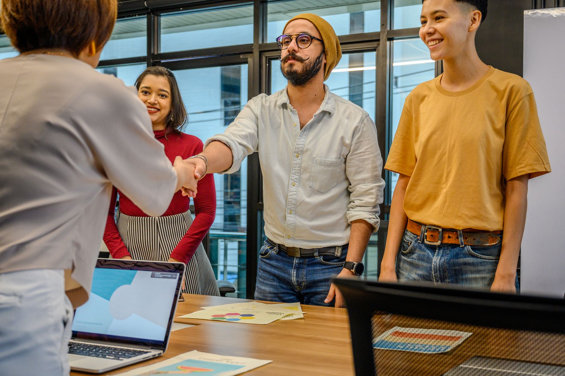 Business team shaking hands at a meeting discussing exit-only share option schemes