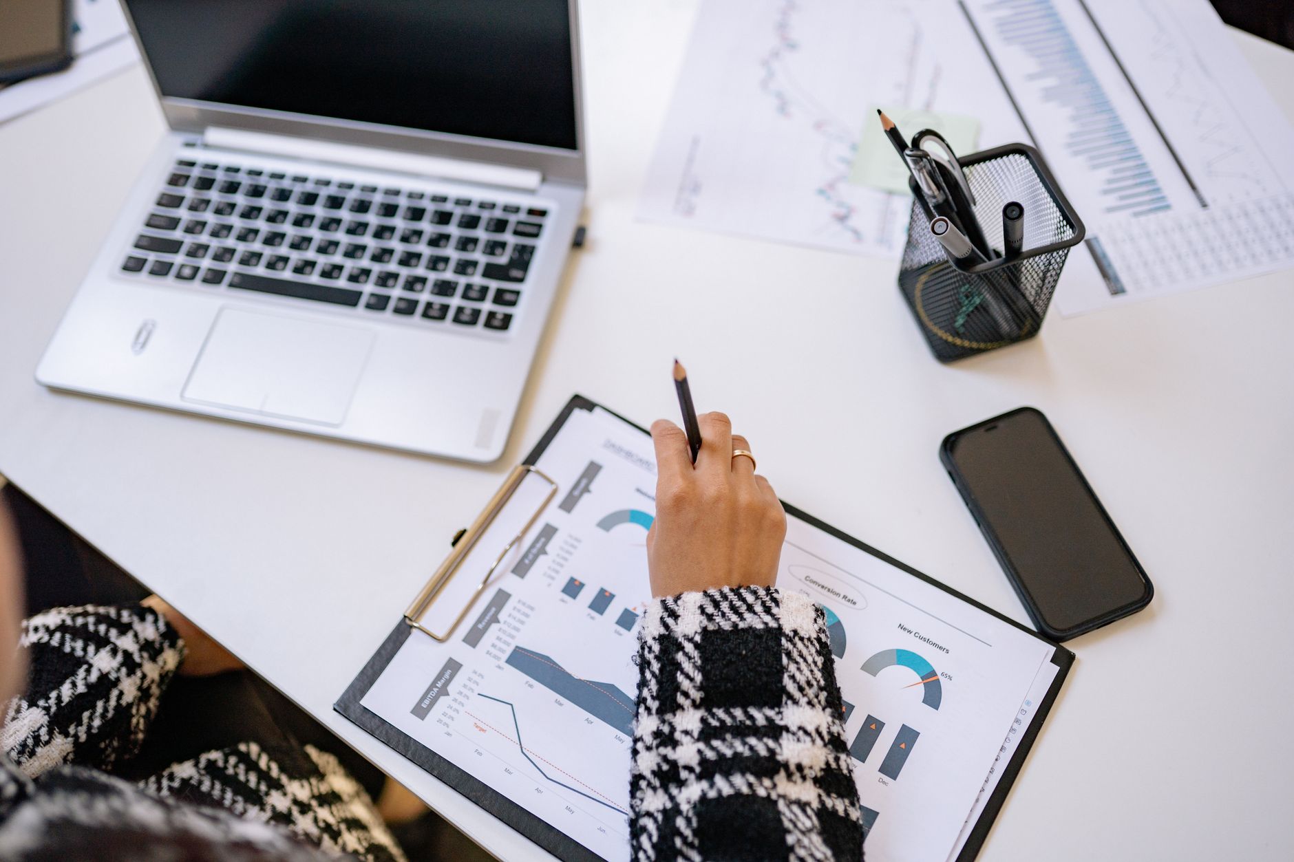 Person reviewing business charts and financial data at a desk, illustrating what size is a small business UK