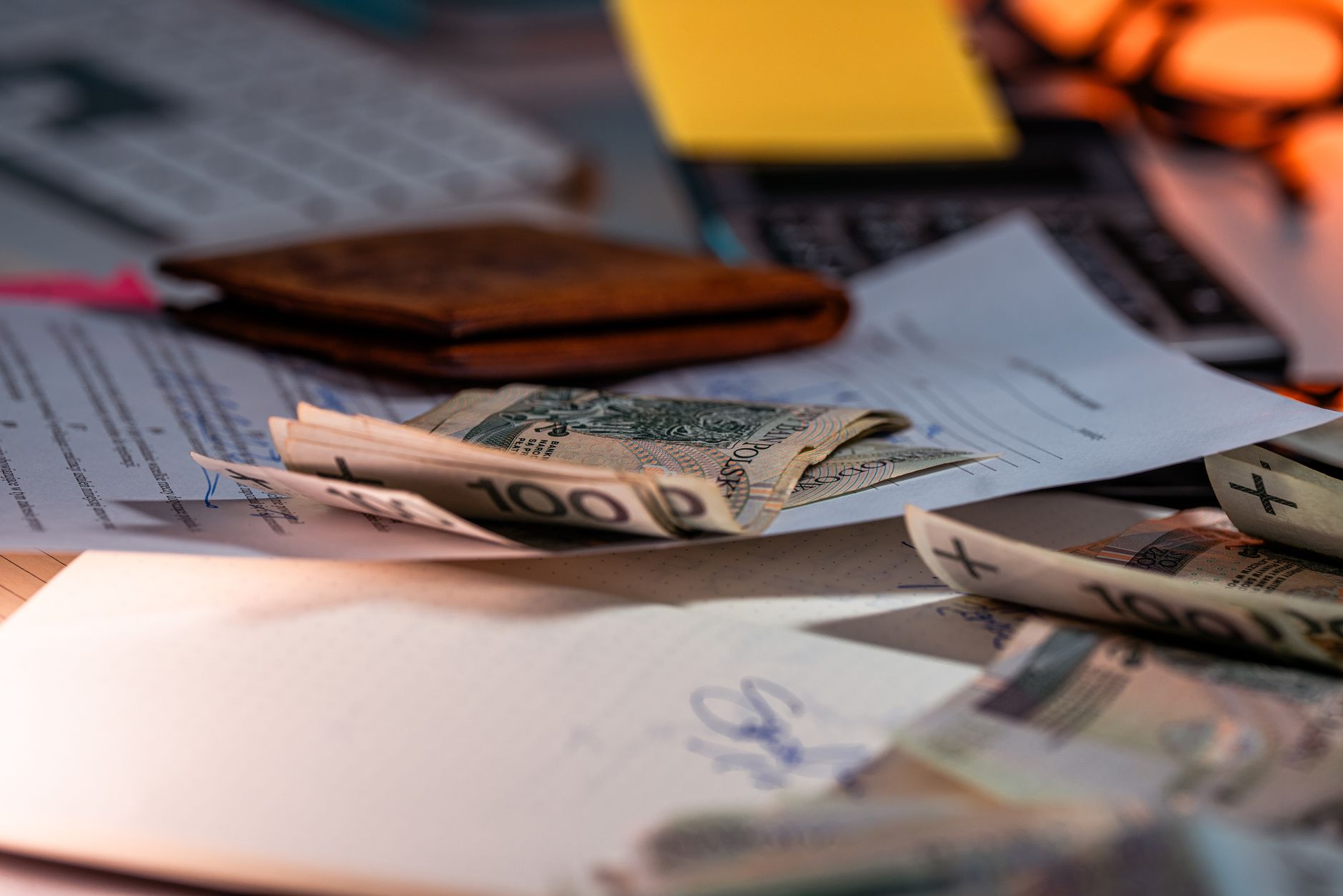 Banknotes, a leather wallet and financial documents on a desk illustrating SME lending confidence